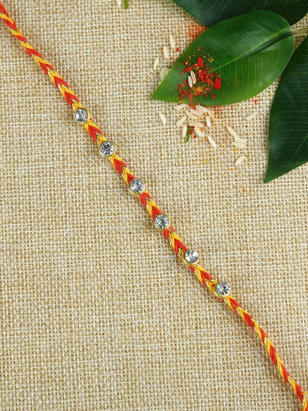 

Aapno Rajasthan Unisex Stone-Studded Thread Rakhi With Roli Chawal, Red