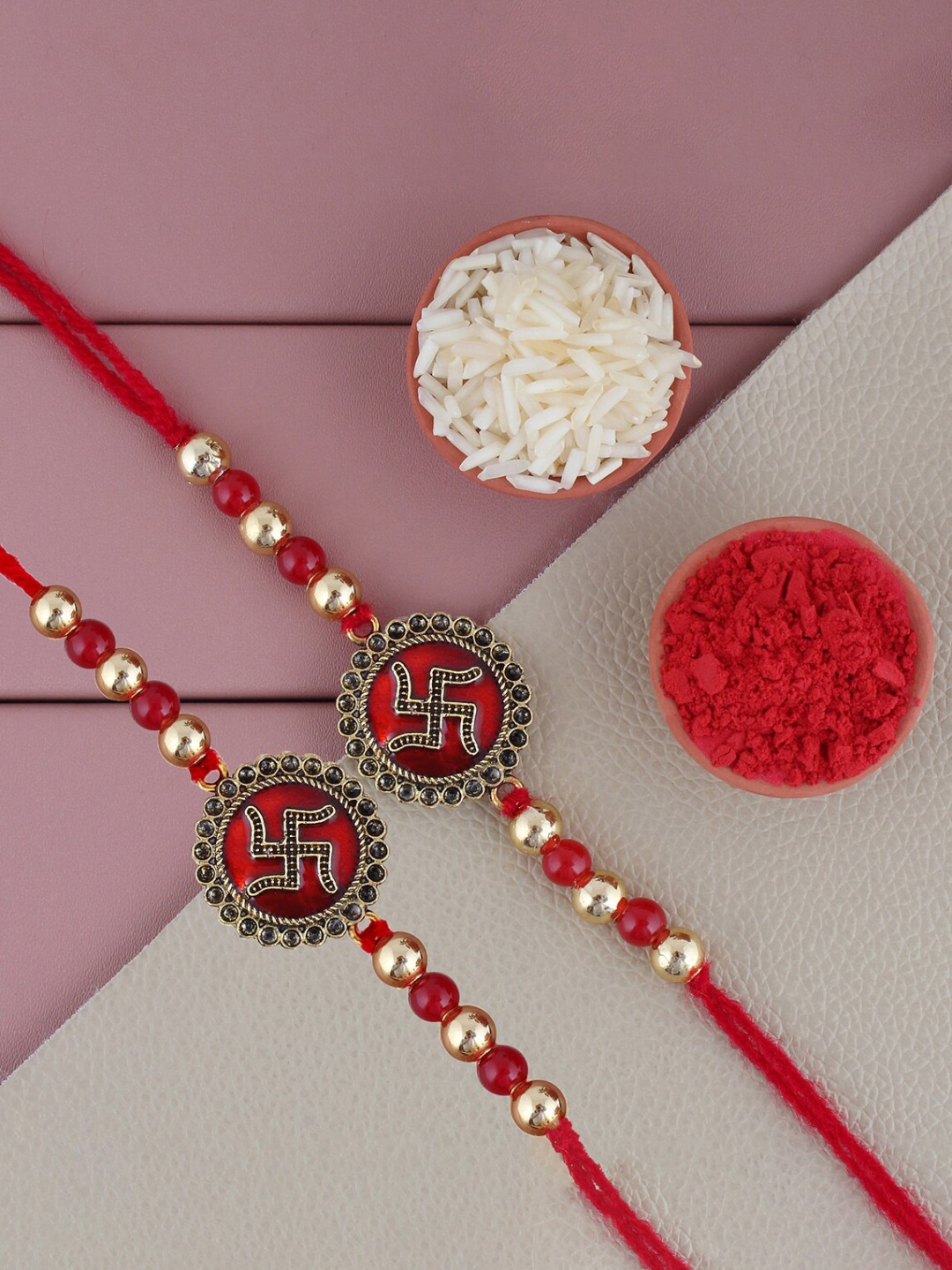 

LUCKY JEWELLERY Set Of 2 Swastik Charm Rakhis With Roli Chawal & Greeting Card, Maroon