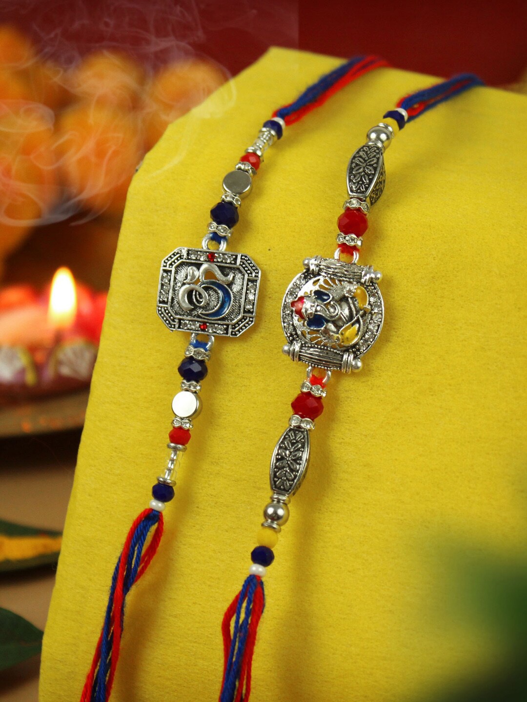 

TIED RIBBONS Set of 2 Ganesha & Om Charm Rakhi With Card, Silver