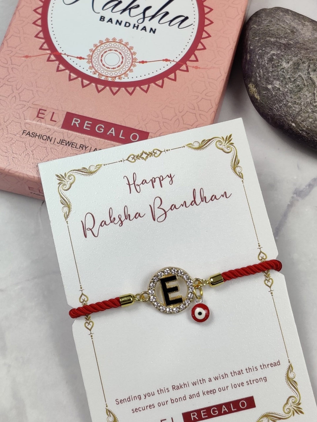 

EL REGALO Unisex E Name Initial Evil Eye Rakhi With Roli chawal Card, Red