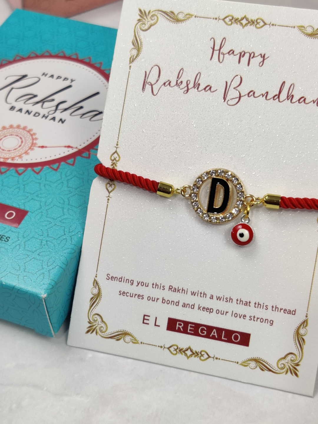 

EL REGALO Unisex D Name Initial Evil Eye Rakhi With Roli chawal Card, Red