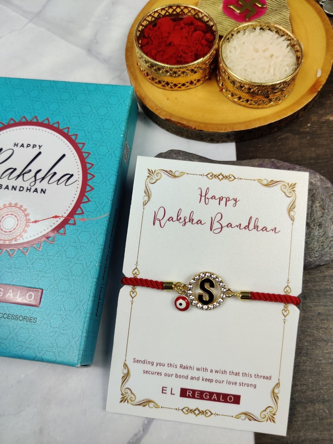 

EL REGALO Stone-Studded Evil Eye Name Initial Rakhi With Roli Chawal Card, Red