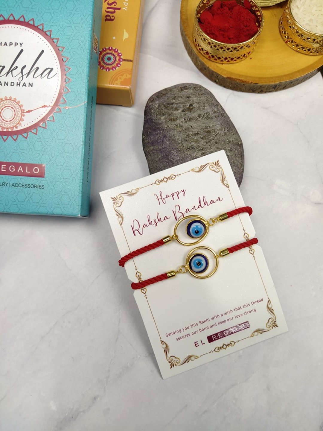 

EL REGALO Bhaiya Bhabhi 2 Pcs Evil Eye Rakhi With Roli Chawal and Card, Red