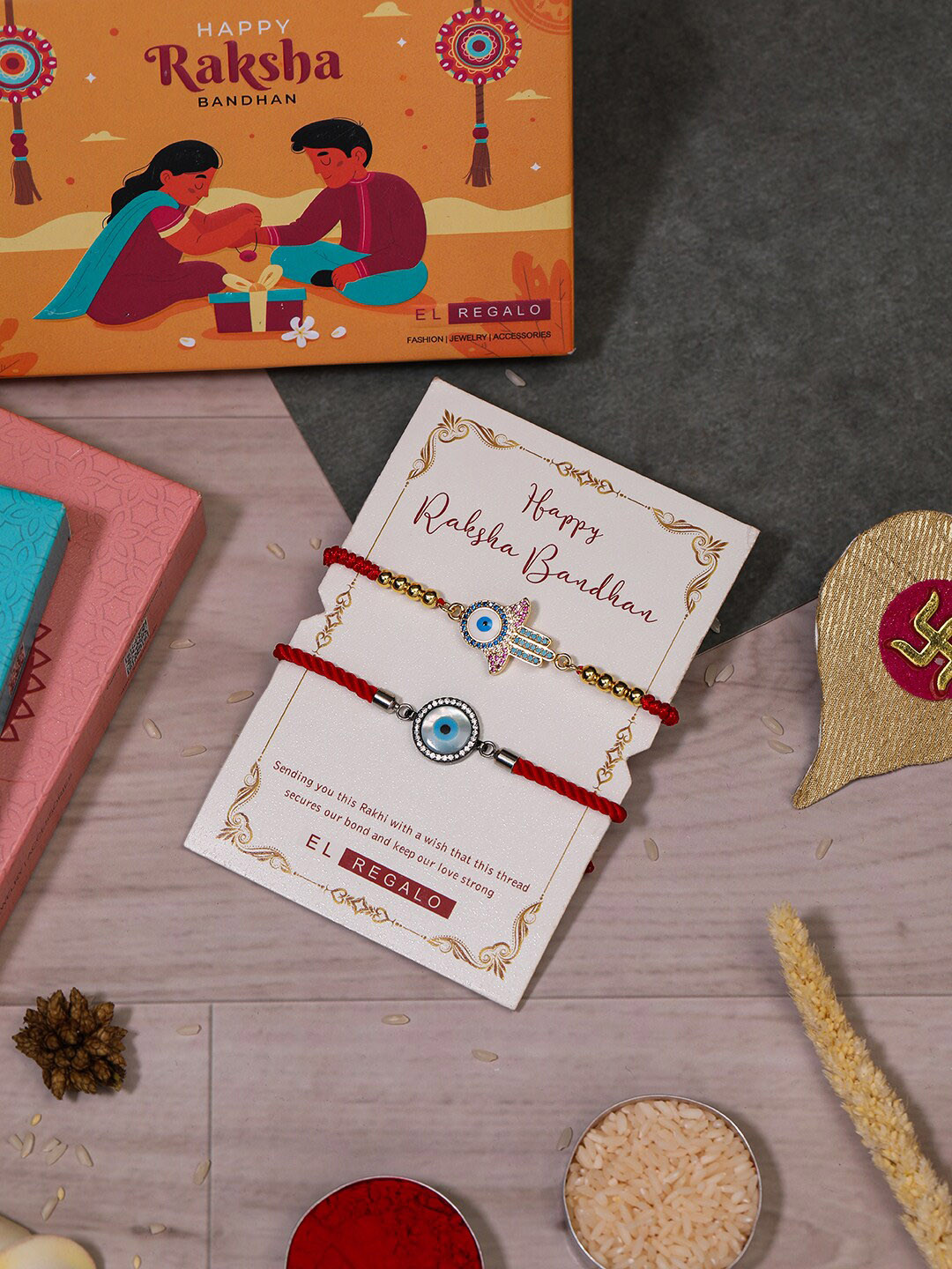 

EL REGALO Bhaiya Bhabhi Set Of 2 Evil Eye Charm Rakhi Combo With Roli Chawal, Red