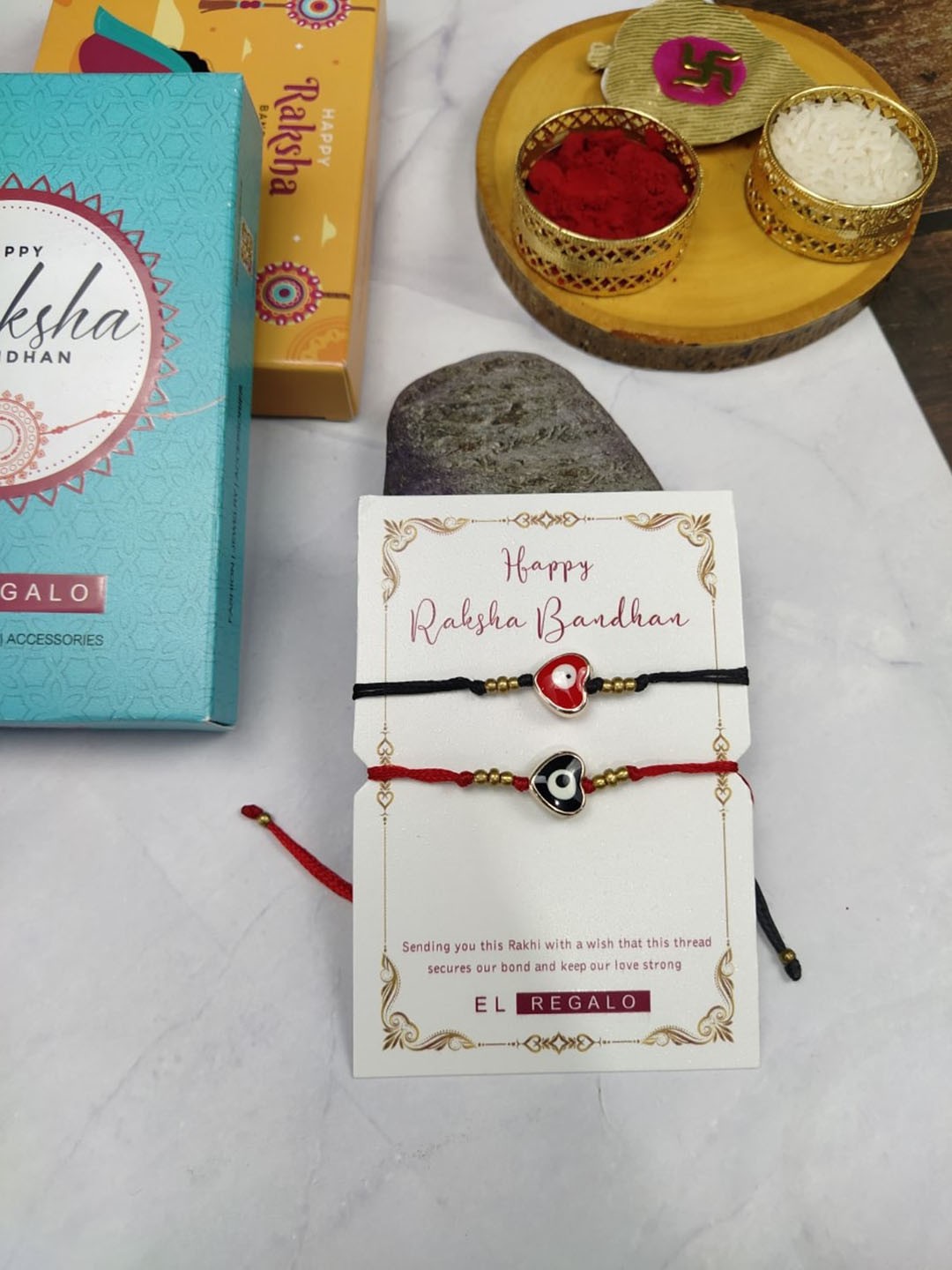 

EL REGALO Bhaiya Bhabhi 2 Pcs Evil Eye Rakhi With Roli Chawal and Card, Red