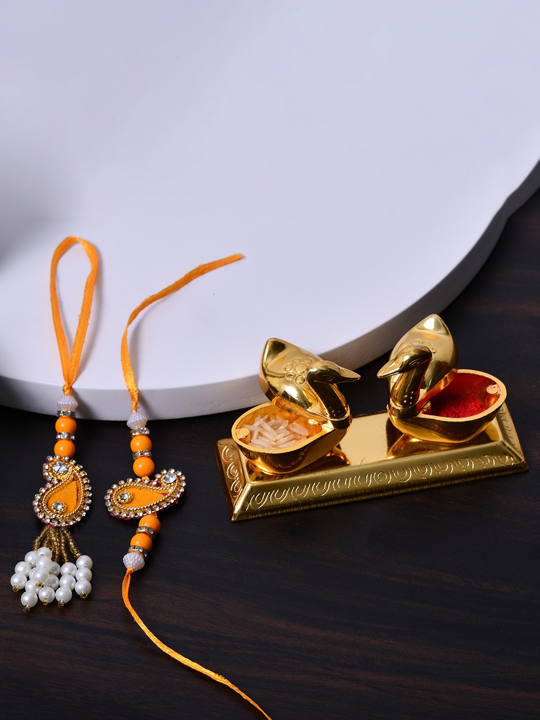 

Fashion Bizz Set Of 3 Thread Rakhis With Roli Chawl & Pooja Thali, Gold