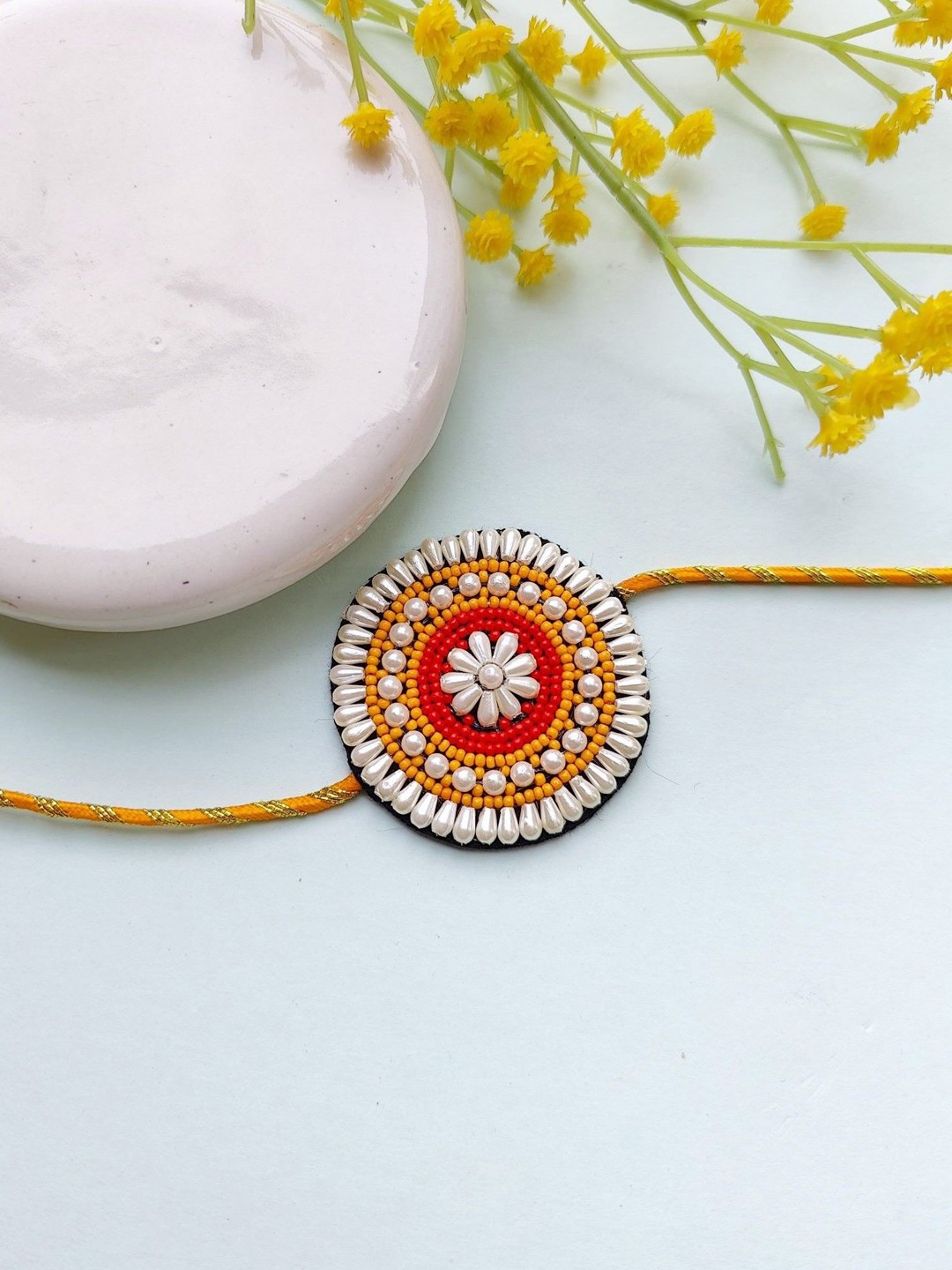 

Crunchy Fashion Beaded Flower Thread Rakhi, White