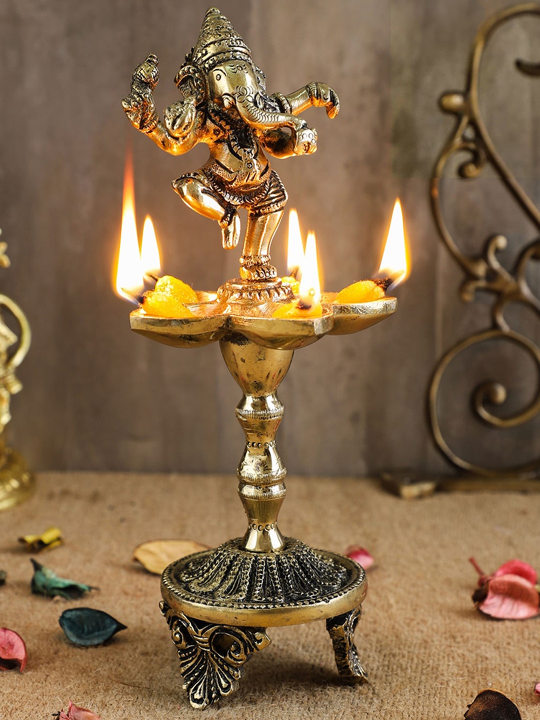 

Two Moustaches Gold-Toned Dancing Ganesha Over Ethnic Legs Five Oil Wick Brass Diya