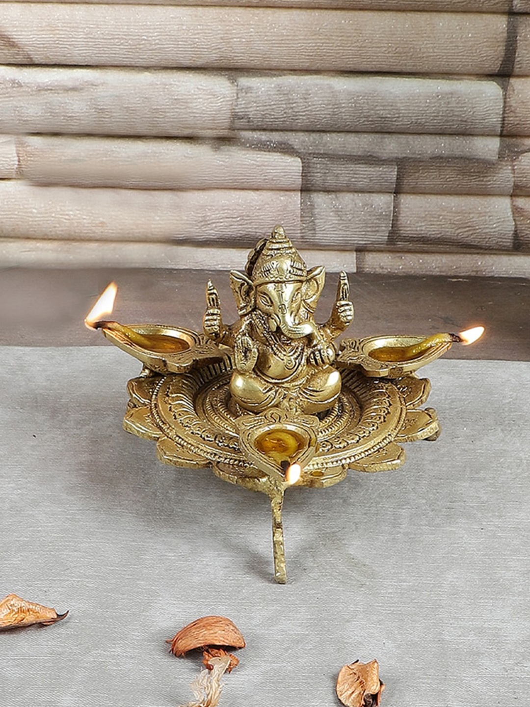 

Two Moustaches Gold Toned Ganesha on Lotus with Three Leaf Design Diya