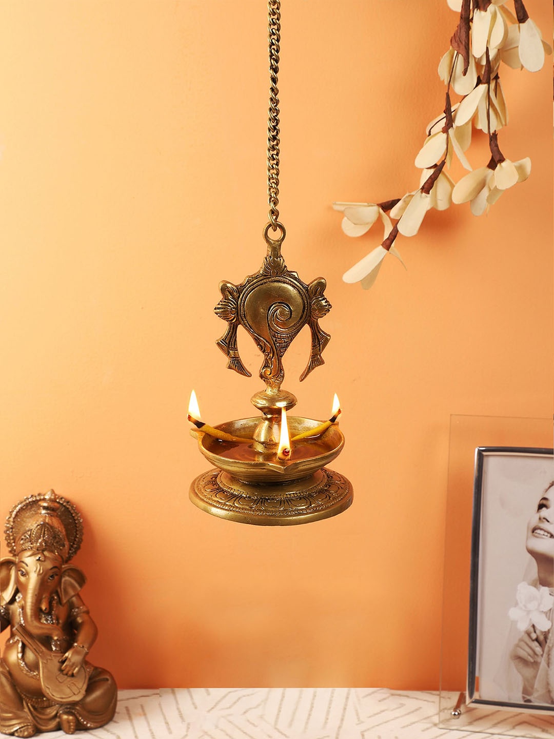 

Two Moustaches Gold Toned Shankh Design Hanging Diya