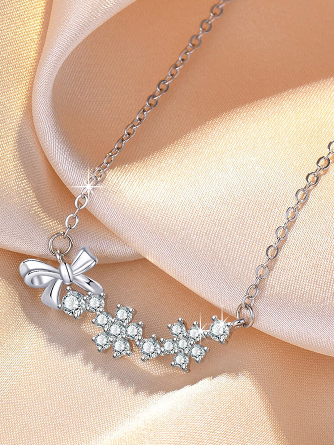 

Jewels Galaxy Silver-Plated AD-Studded Bow-Tie Themed Pendant With Chain