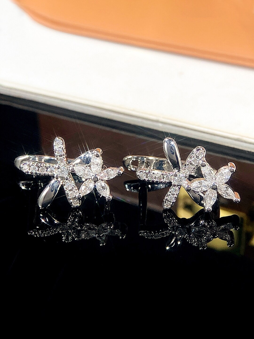 

Jewels Galaxy Silver-Plated American Diamond Studded Floral Shaped Studs Earrings