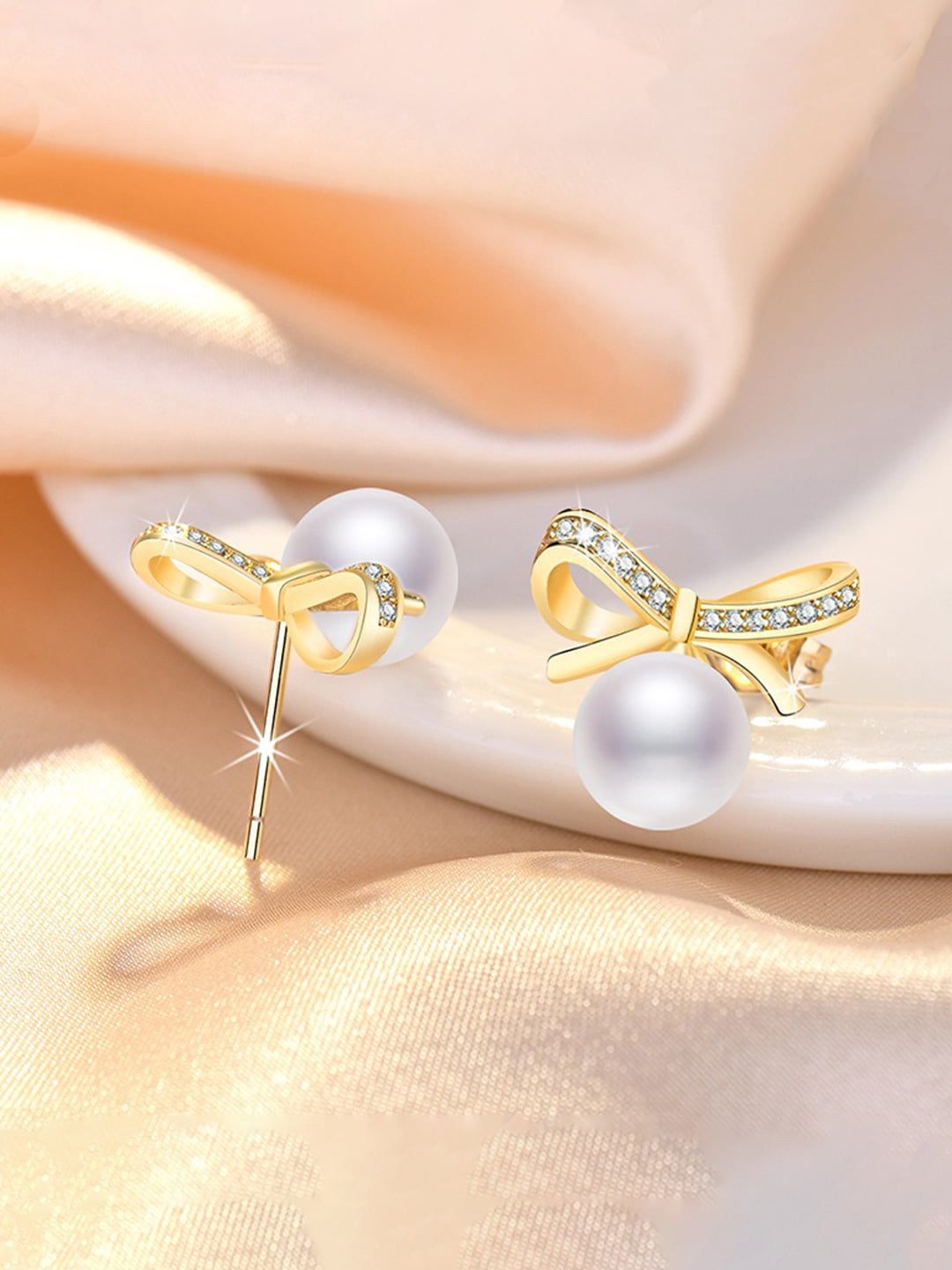 

Jewels Galaxy Gold Plated American Diamond Studded Bow-Tie Shape Studs Earrings