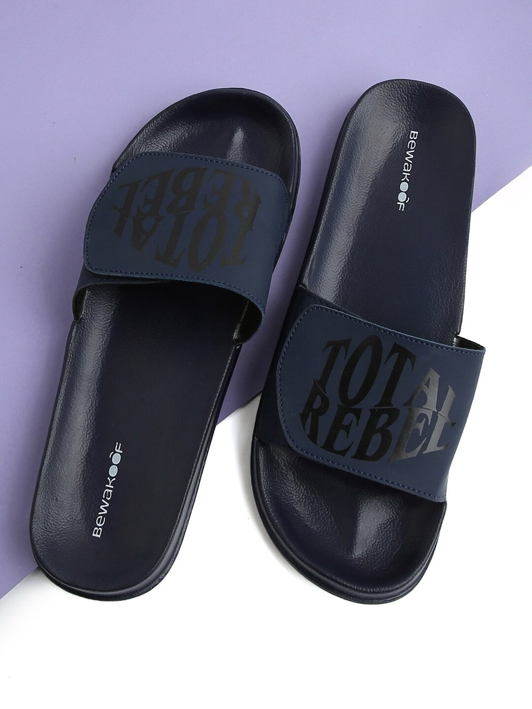 

Bewakoof Men Black Total Rebel Printed Rubber Sliders, Blue
