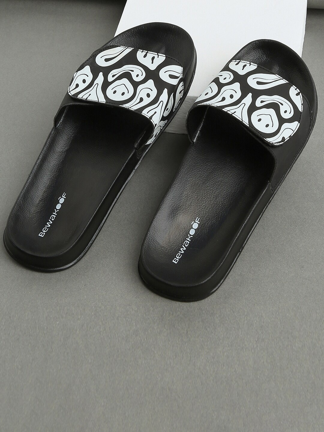 

Bewakoof Men Black Drippin Smile Printed Rubber Sliders