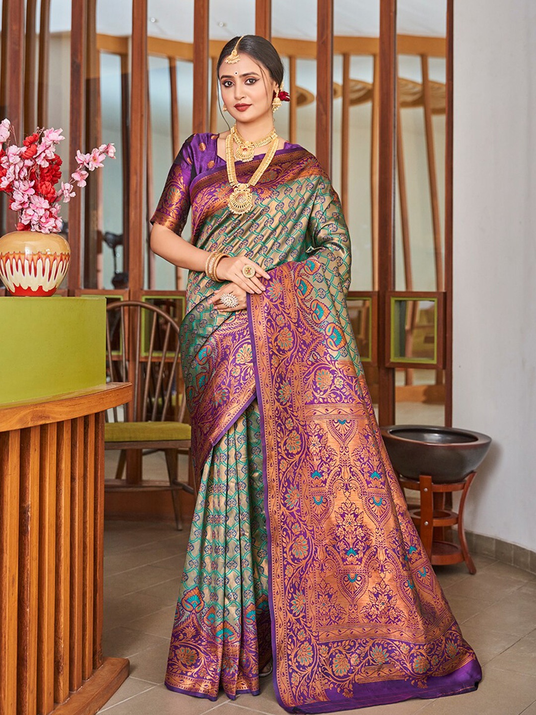 

Mitera Teal & Purple Ethnic Motifs Woven Design Zari Banarasi Saree