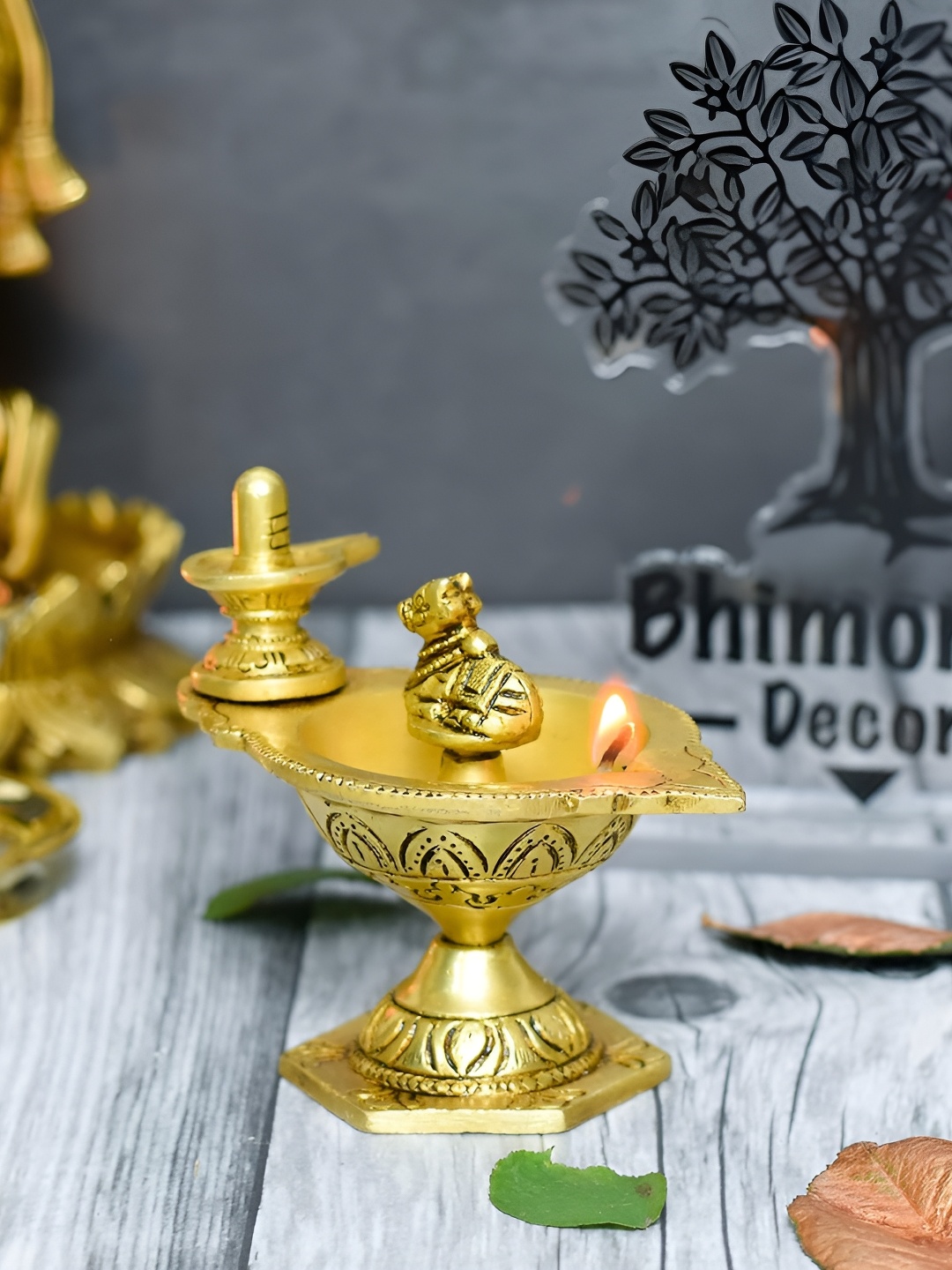 

Bhimonee Decor Aarti Gold Toned Shivling & Nandi Table Diya Pooja Essentials