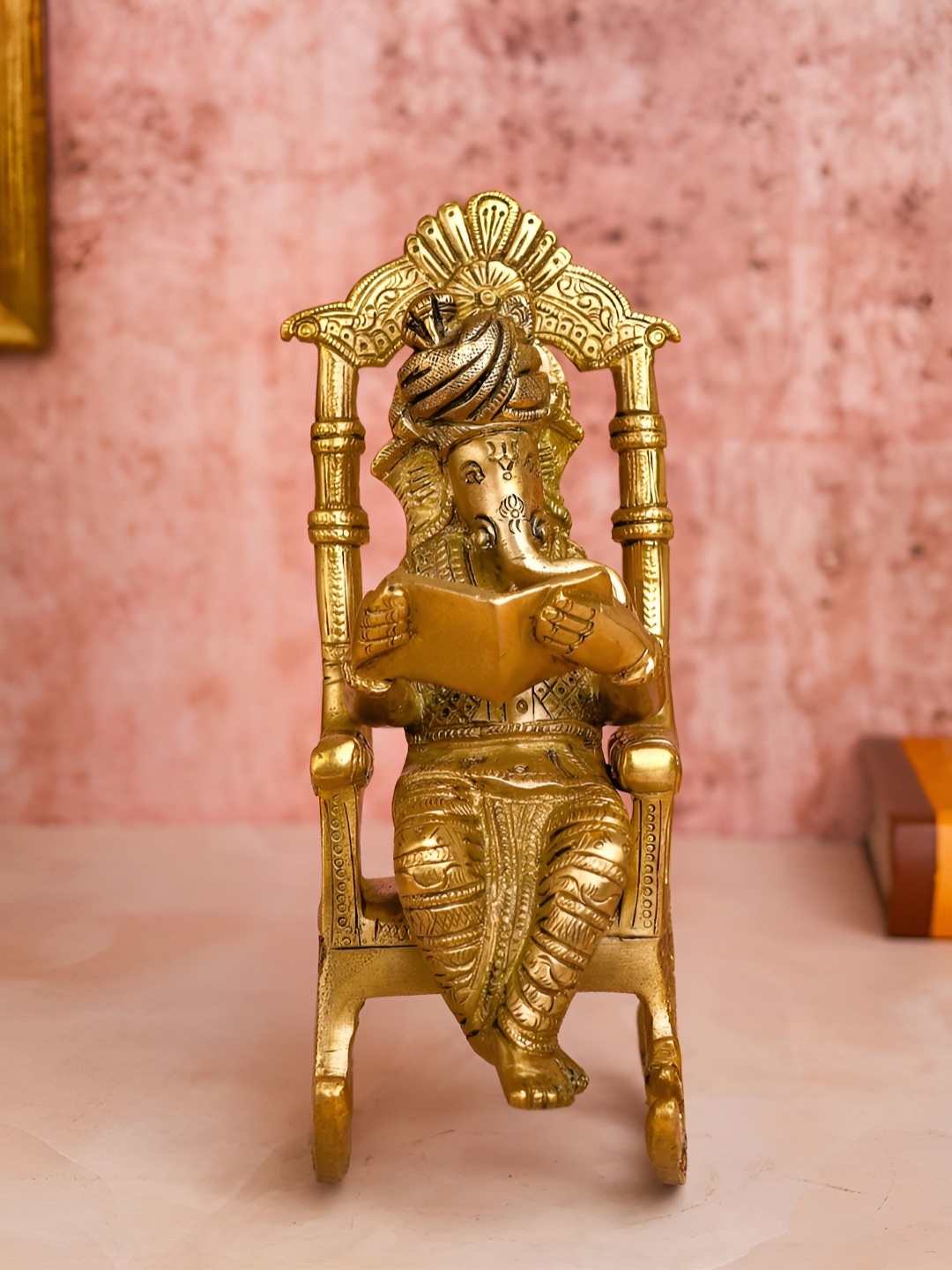 

The Advitya Gold Toned Brass Ganesha Reading Book On Rocking Chair Showpiece