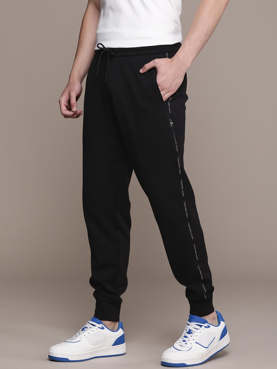 

Calvin Klein Jeans Men Solid Regular Fit Mid-Rise Regular Joggers With Side Print Detail, Black