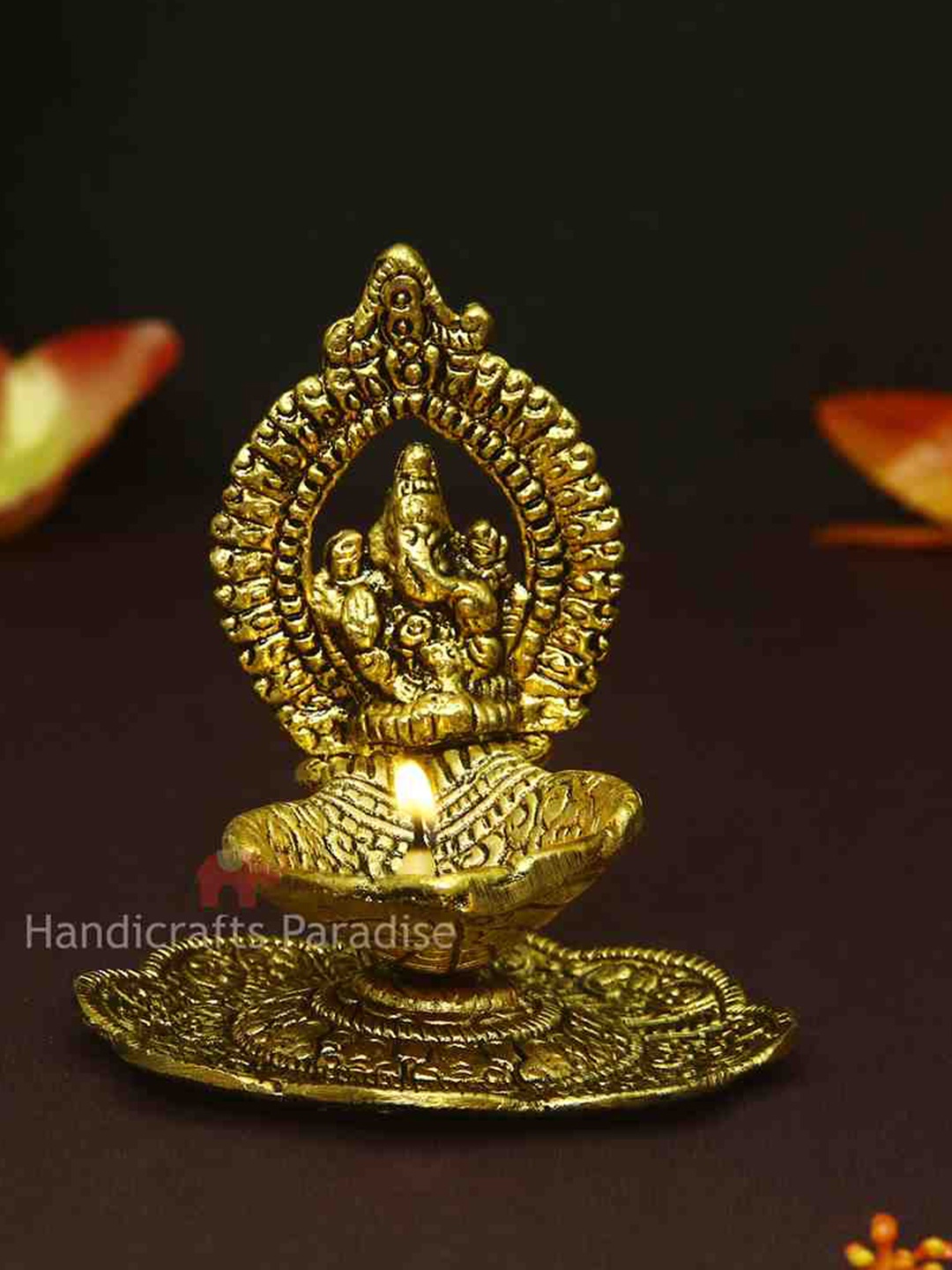 

HANDICRAFTS PARADISE Gold Toned Lord Ganesh & Flower Designed Antique Metal Pooja Diya