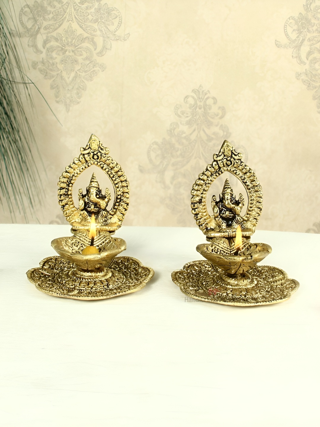 

HANDICRAFTS PARADISE Gold Toned 2 Pcs Ganesh Diyas With Swastik Engraved