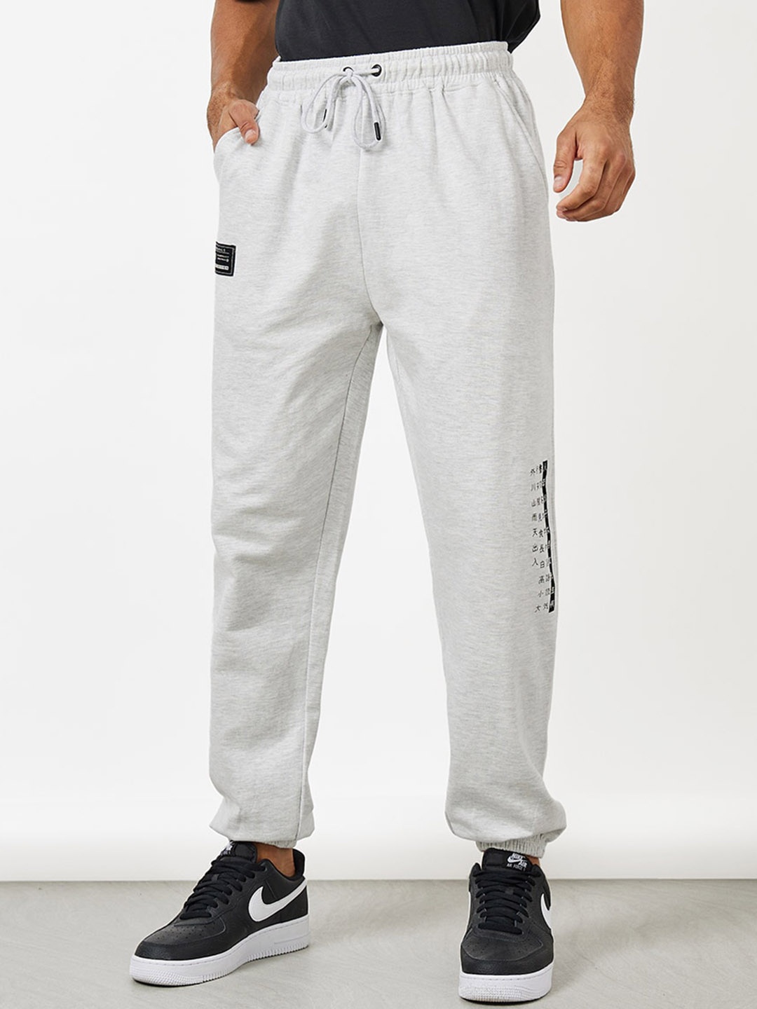 

Styli Men Placement Print Oversized Jogger with Badge Detail, Grey