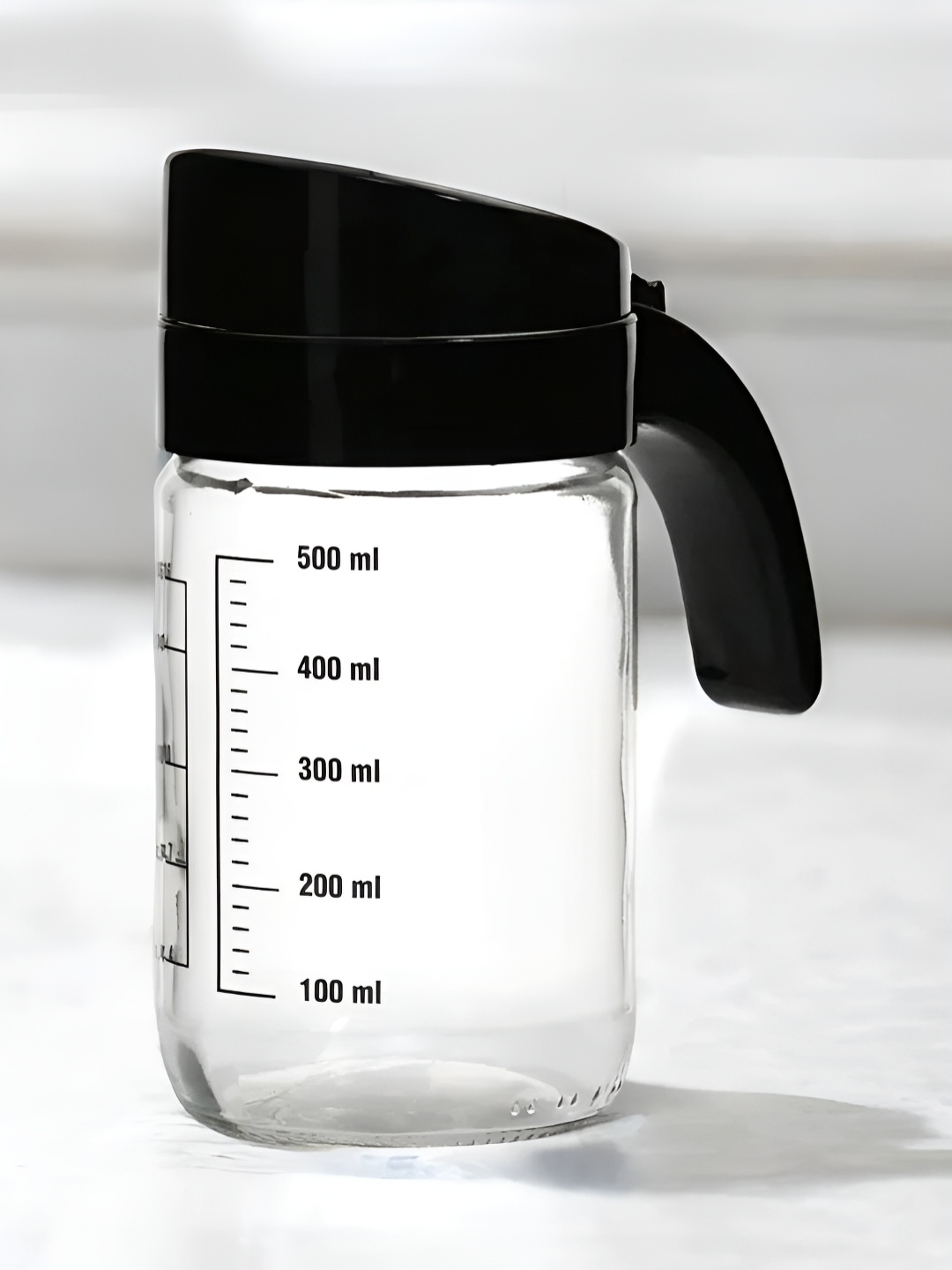 

Athome by Nilkamal Transparent Black Glass Oil Measure Jar With Lid 660 Ml