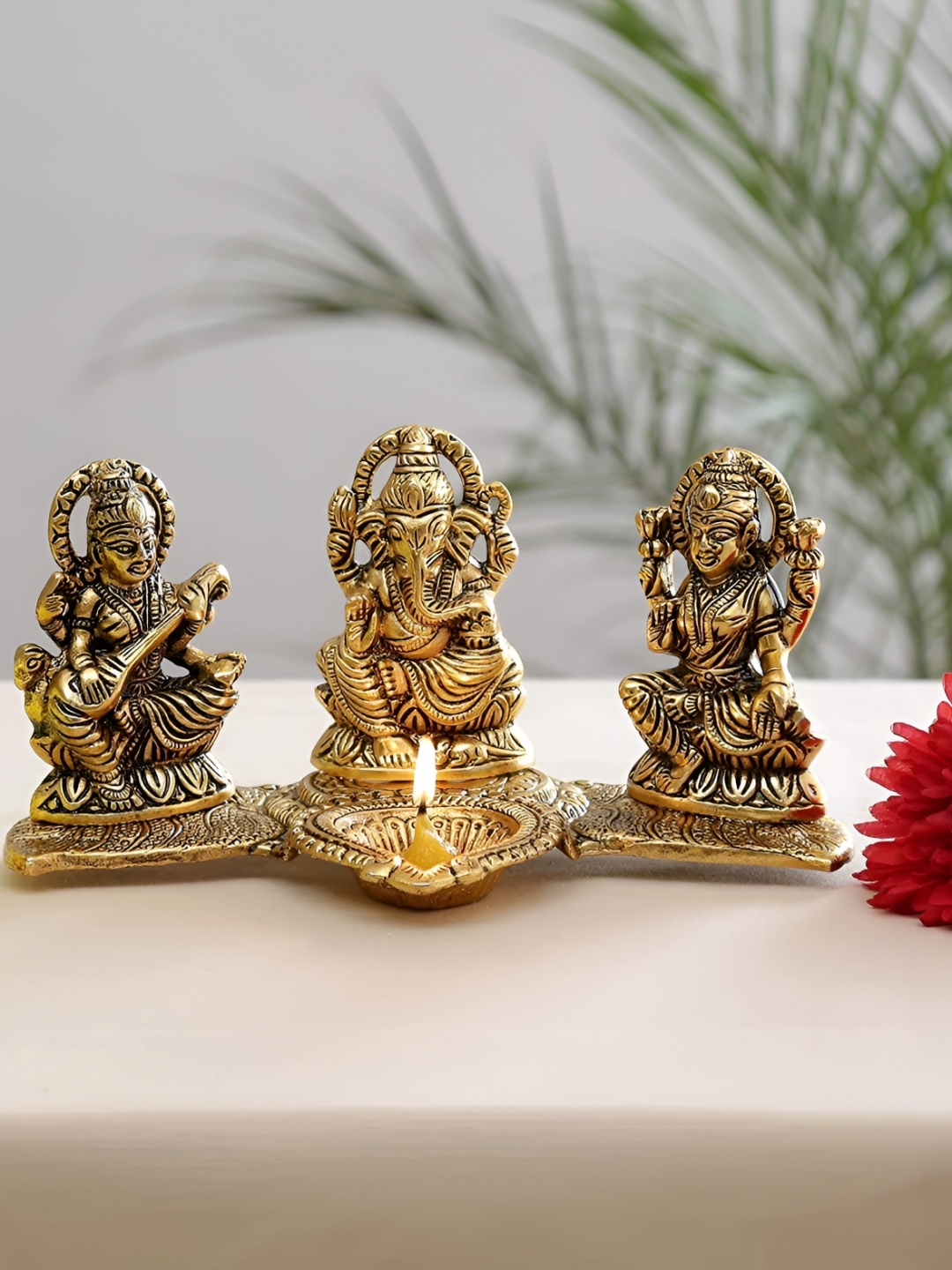 

Kridaykraft Gold Toned Laxmi Ganesha Saraswati With Diya Religious Idol Showpiece