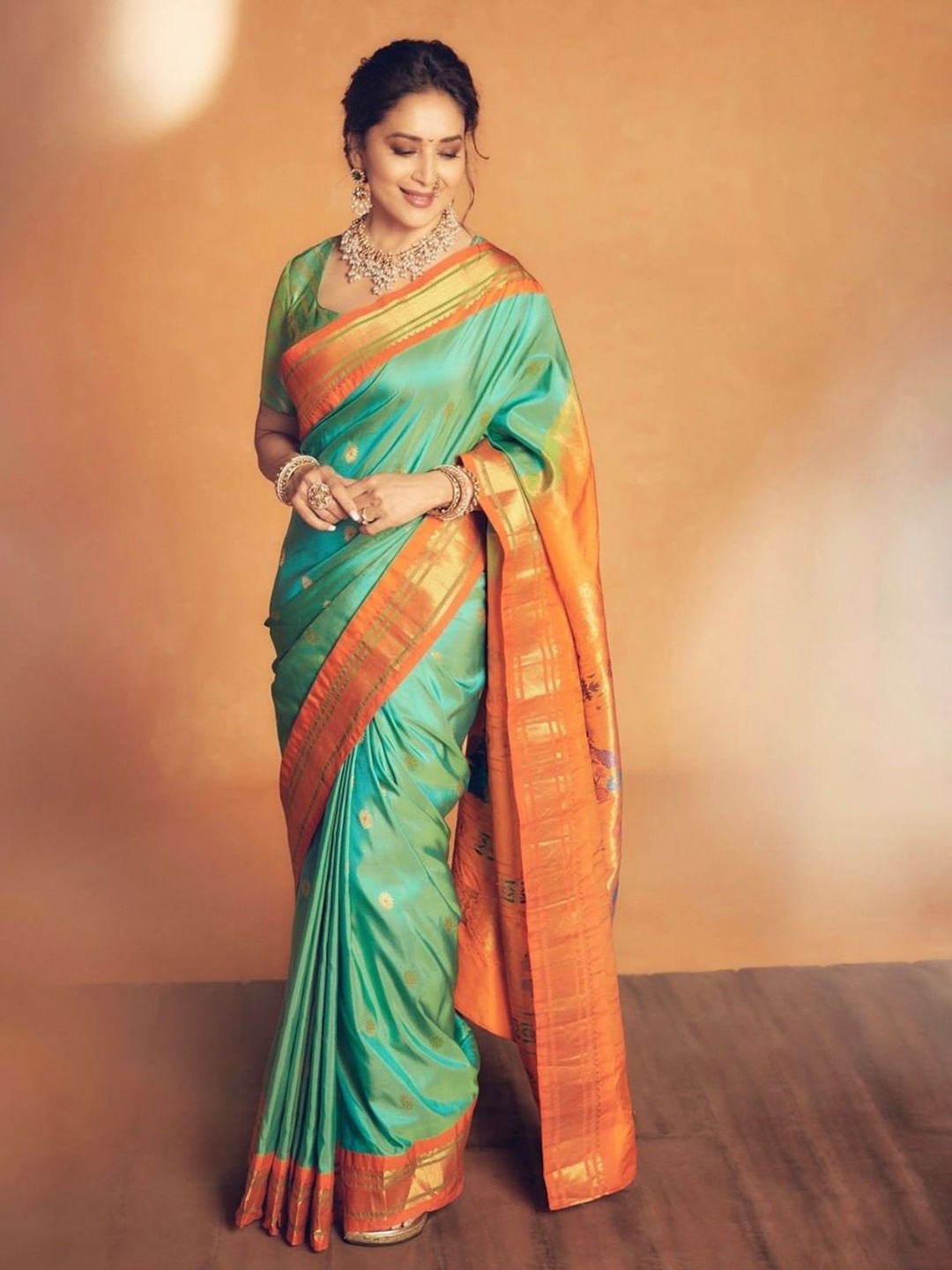 

Mitera Green & Orange Ethnic Motifs Woven Design Zari Art Silk Saree