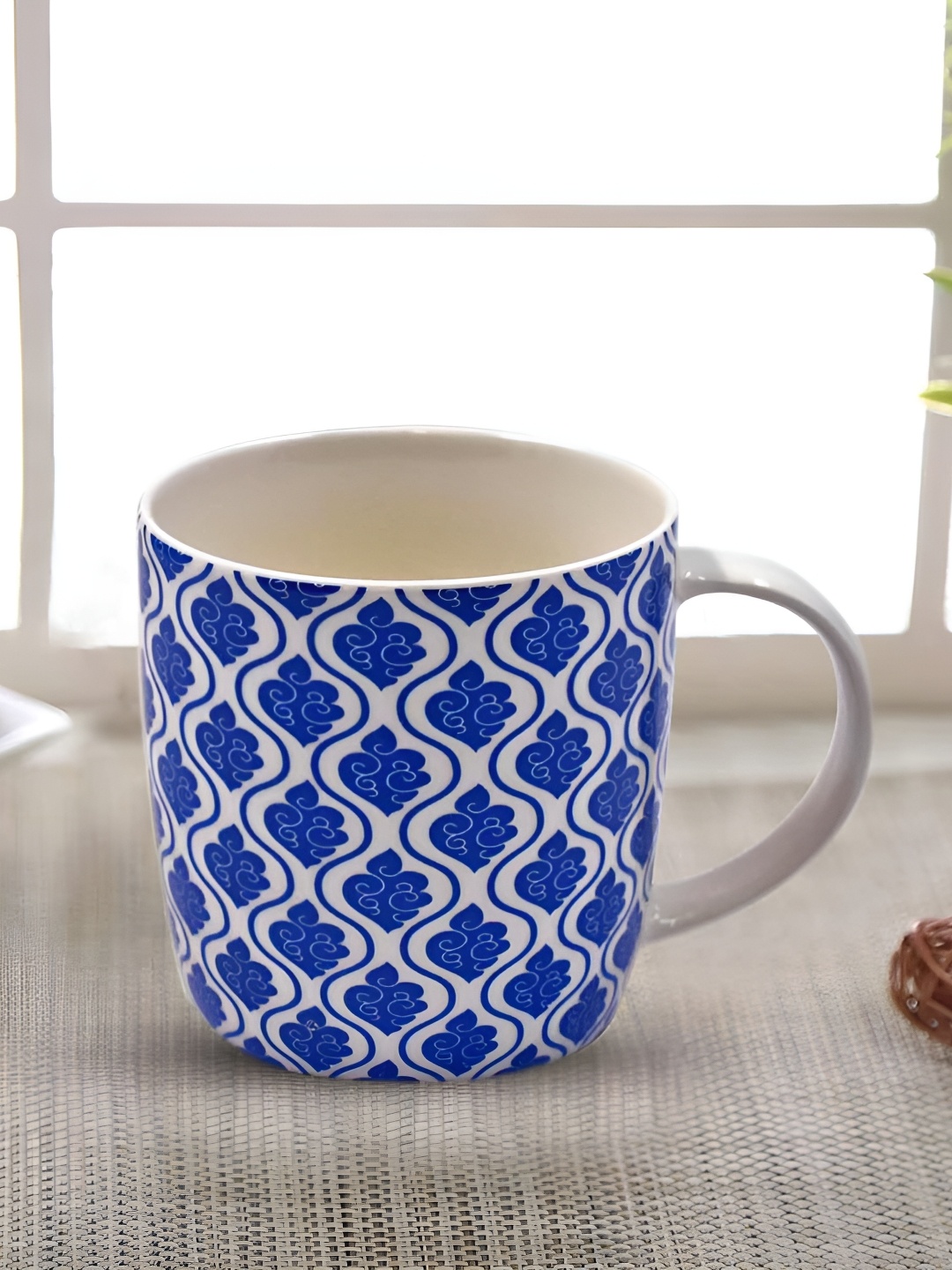 

Kookee White & Blue Floral Printed Ceramic Glossy Mug with handle 325 ml