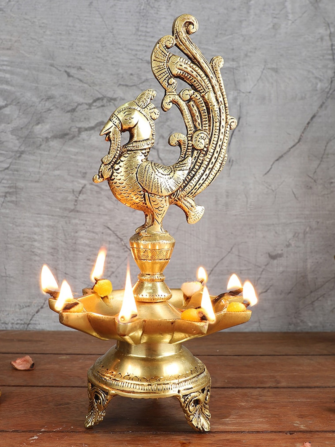 

Two Moustaches Gold Toned Peacock Shape Brass Diya