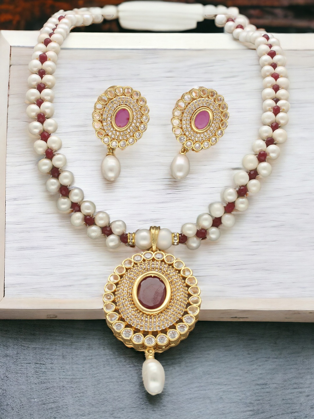 

Sri Jagdamba Pearls Dealer Gold-Plated Stone Studded & Pearls Beaded Jewellery Set