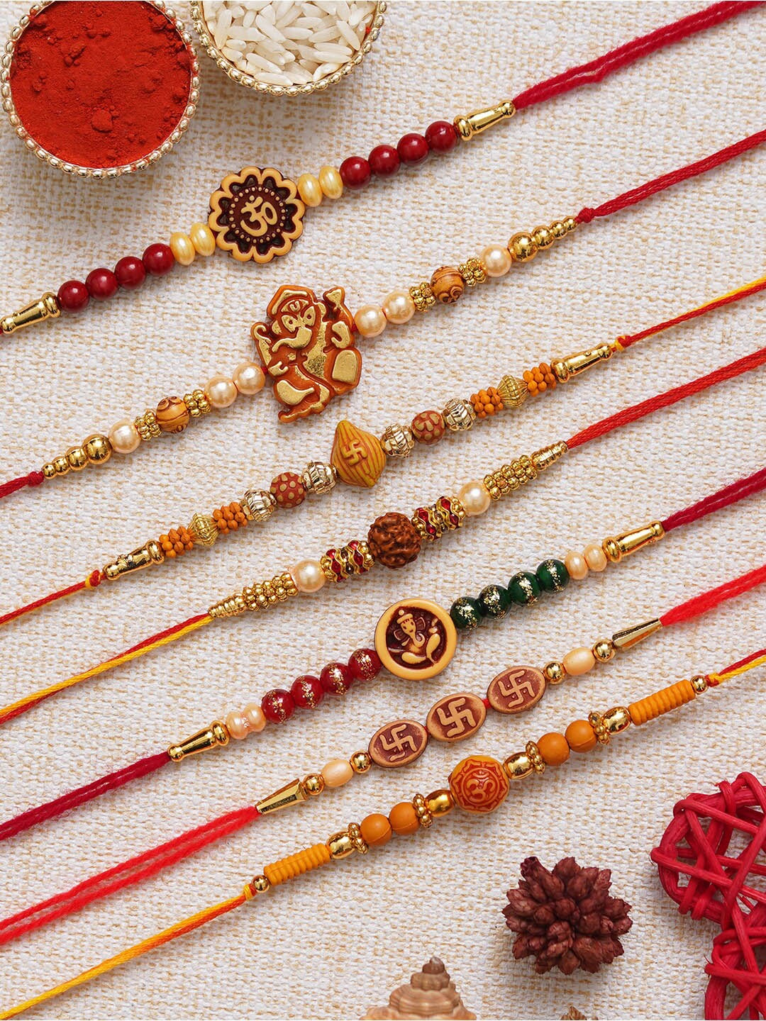 

eCraftIndia Set of 7 Om Ganesha Swastik Rudraksha Faux Pearl Rakhis with Roli Chawal, Red