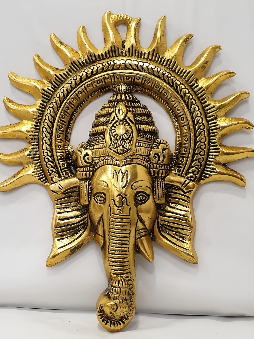 

ANSHIKA INTERNATIONAL Beige Ganesha Idol With Surya Chakra Metal Hanging Wall Mask