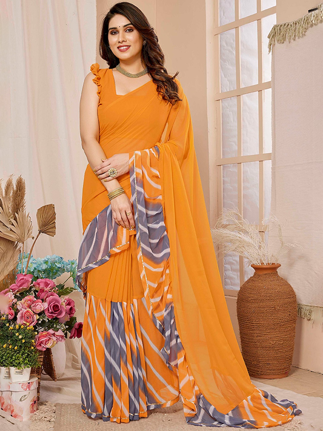 

Mitera Orange Leheriya Printed Ruffles Saree