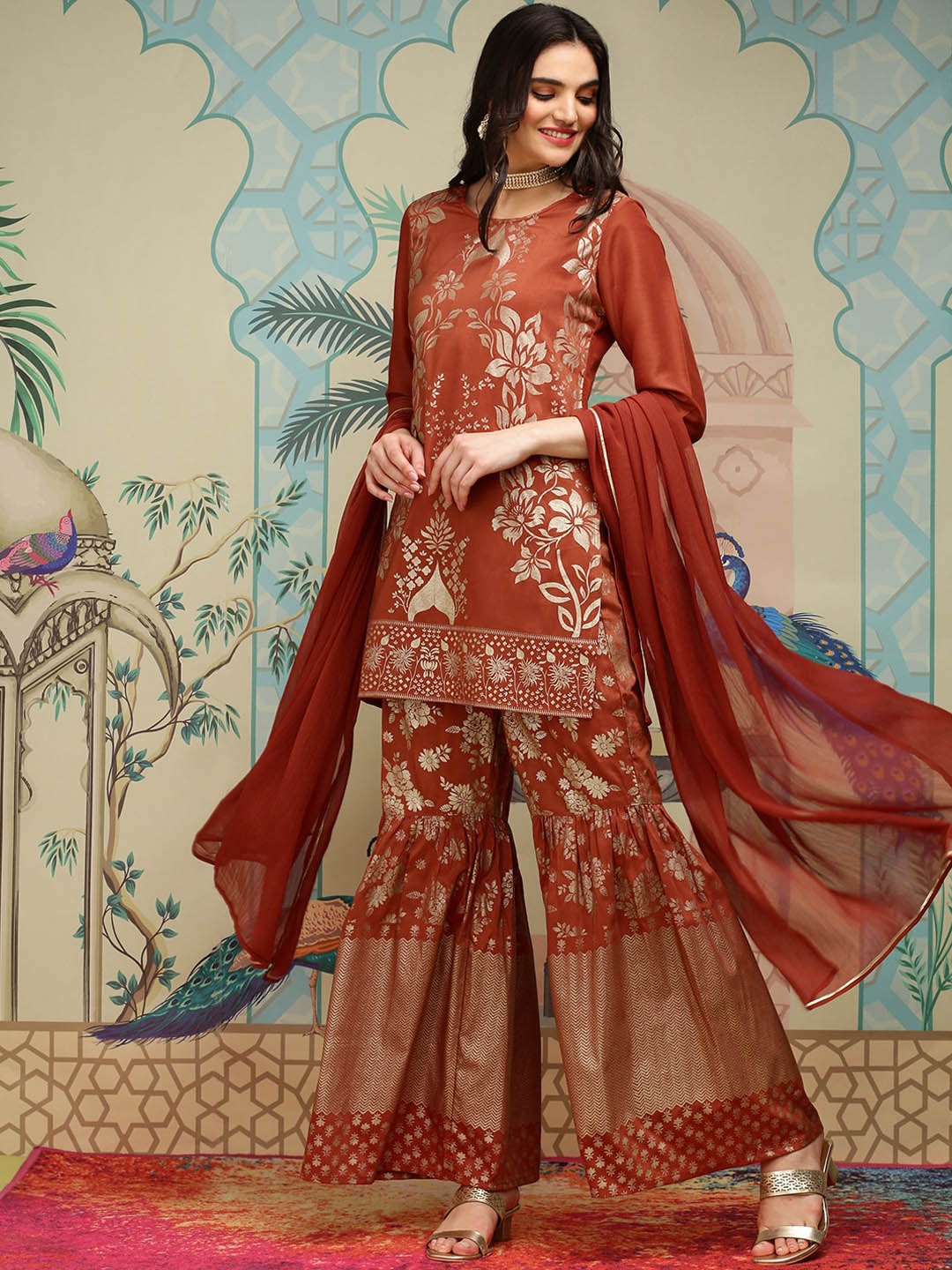 

Ishin Floral Printed Round Neck Three-Quarter Sleeves Kurti with Sharara & With Dupatta, Rust