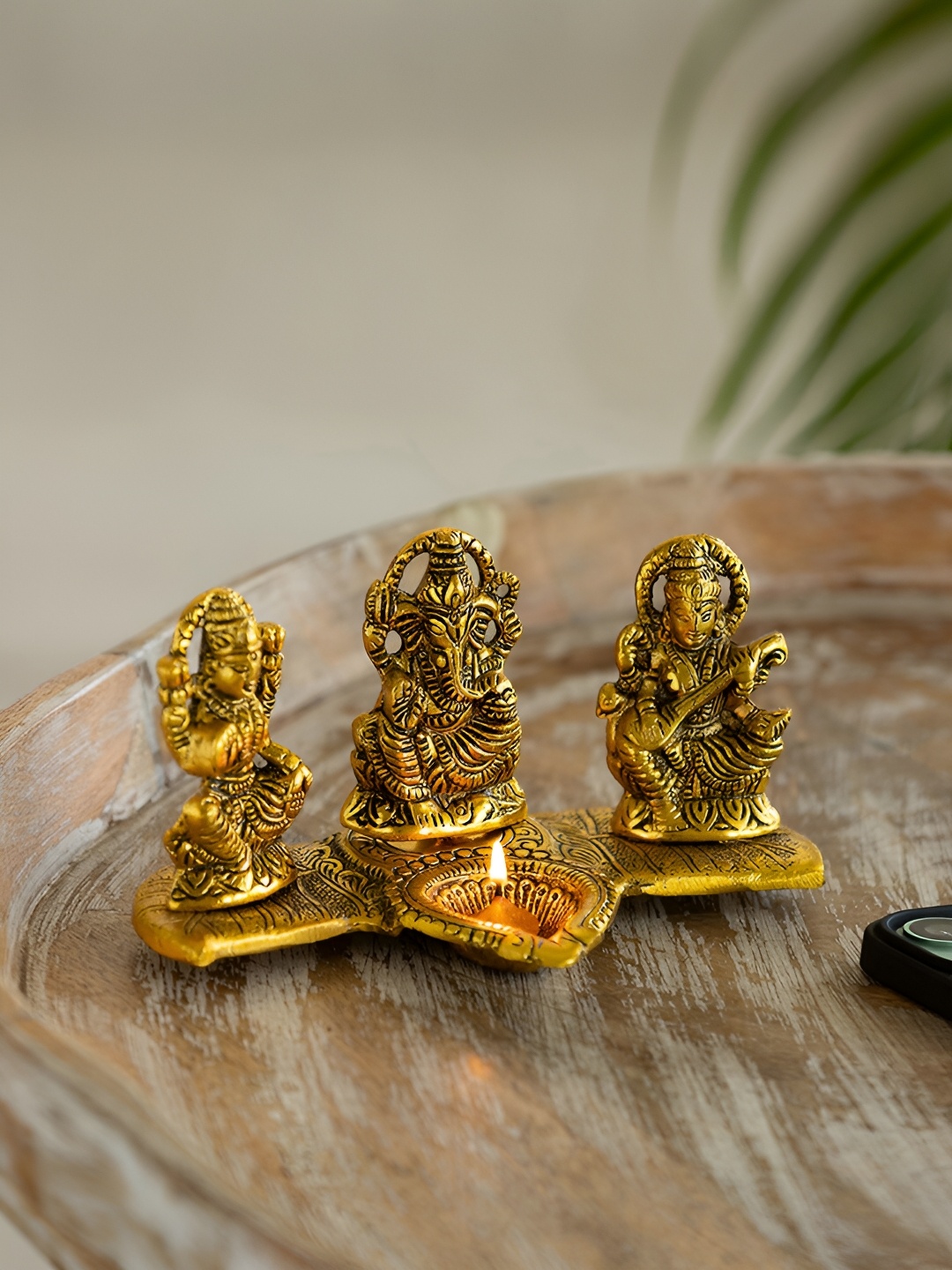 

ExclusiveLane Gold Toned Laxmi Ganesh & Saraswati Idol & Diya Decorative Figurines