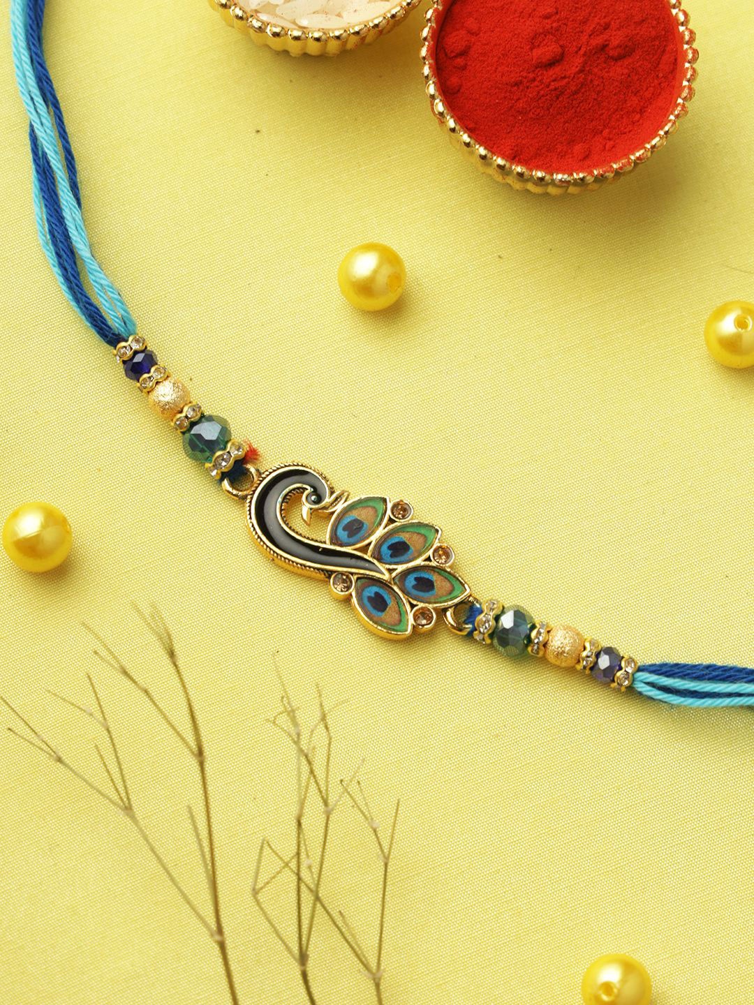 

Aapno Rajasthan Peacock Feather Beaded Rakhi With Roli Chawal & Greetings Card, Blue