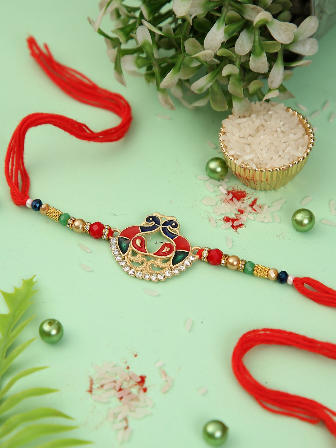 

Aapno Rajasthan Peacock Enamled Beaded Rakhi With Roli Chawal & Greetings Card, Red