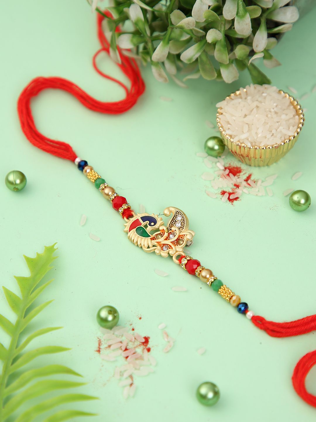 

Aapno Rajasthan Peacock Elegance Gem Rakhi With Roli Chawal & Greetings Card, Gold