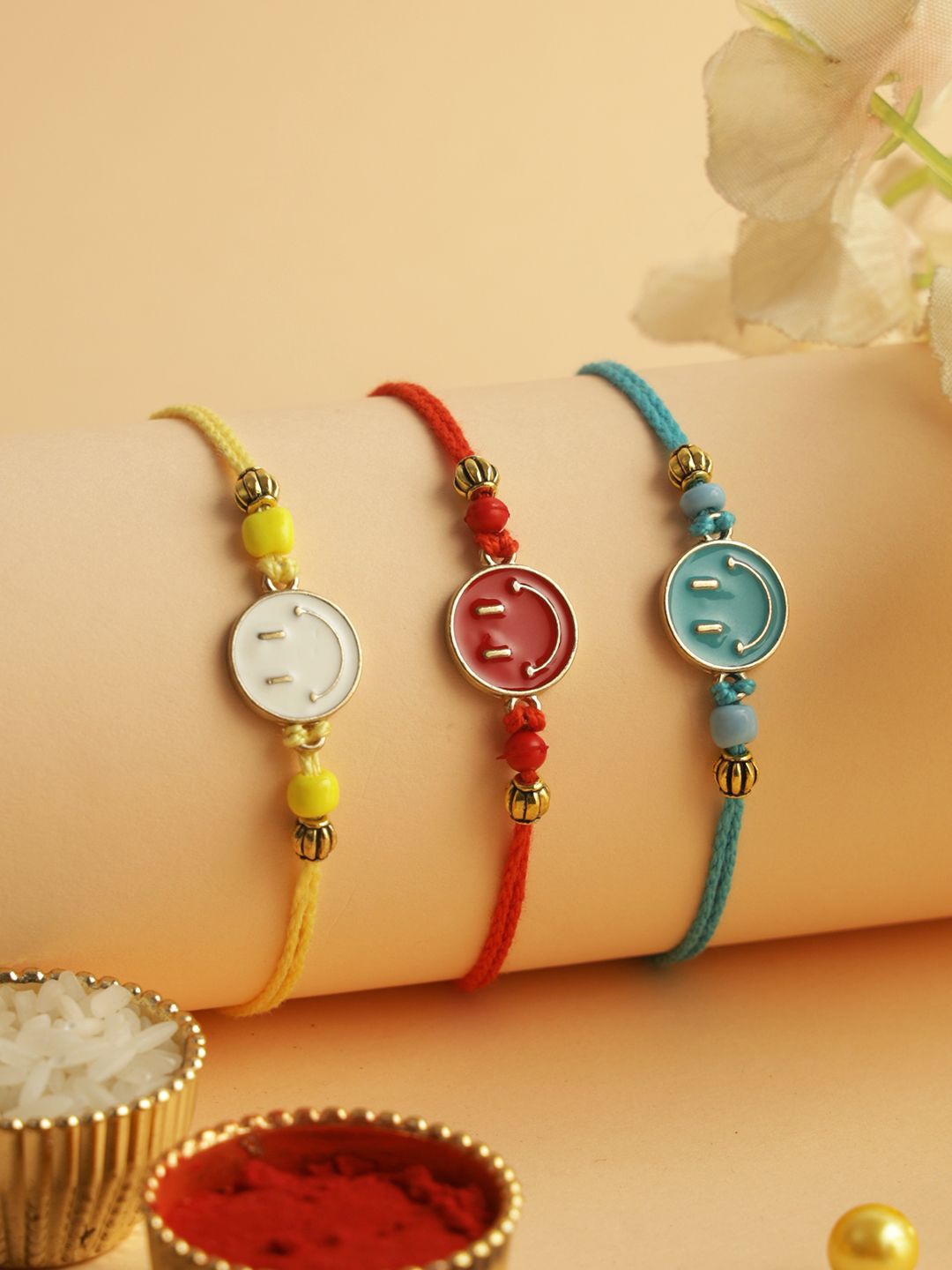 

Aapno Rajasthan Set of 3 Smiley Enameled Rakhi with Roli Chawal & Greeting Card, Red