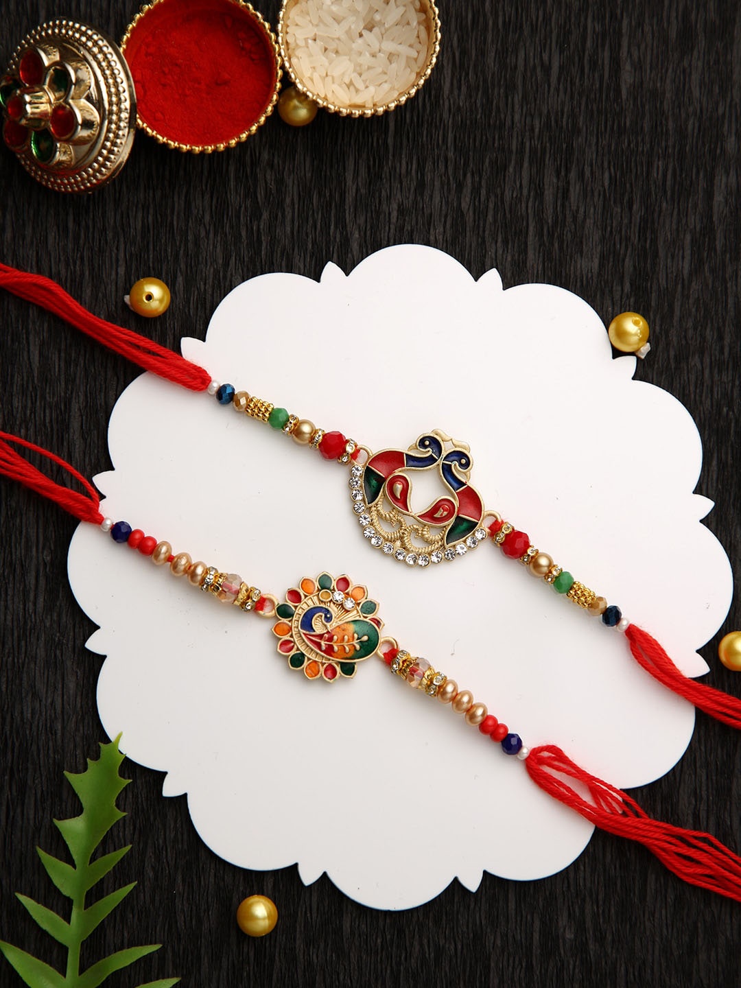 

Aapno Rajasthan Set of 2 Peacock Beaded Rakhi with Roli Chawal & Greeting Card, Red