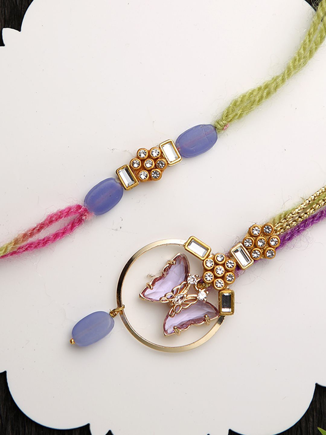

Aapno Rajasthan Butterfly Bhaiya Bhabhi Rakhi With Roli Chawal & Greetings Card, Purple
