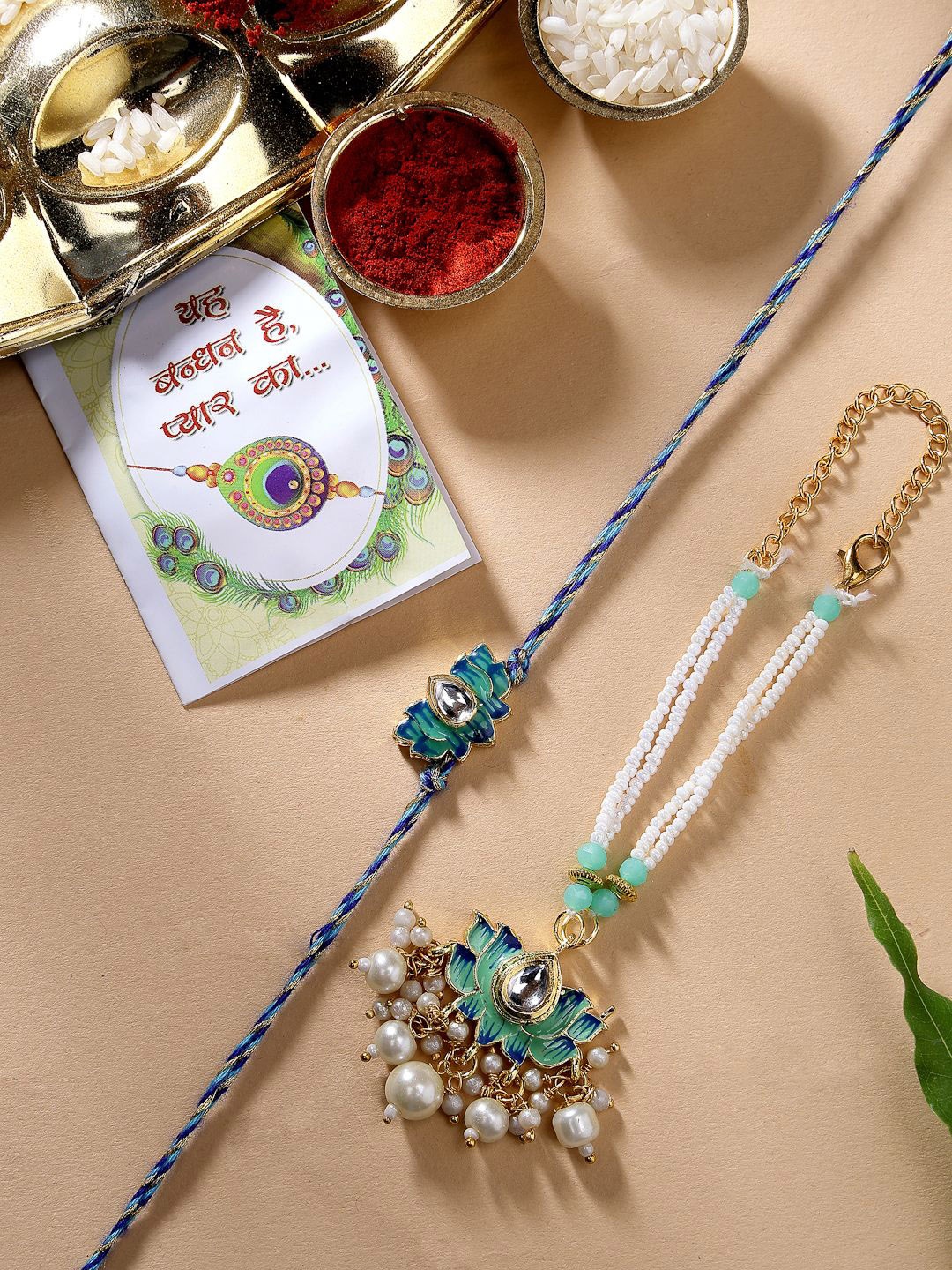

NVR Set of 2 Lotus Stone-Studded & Beaded Bhaiya Bhabhi Rakhi with Roli Chawal & Chocolate, Turquoise blue