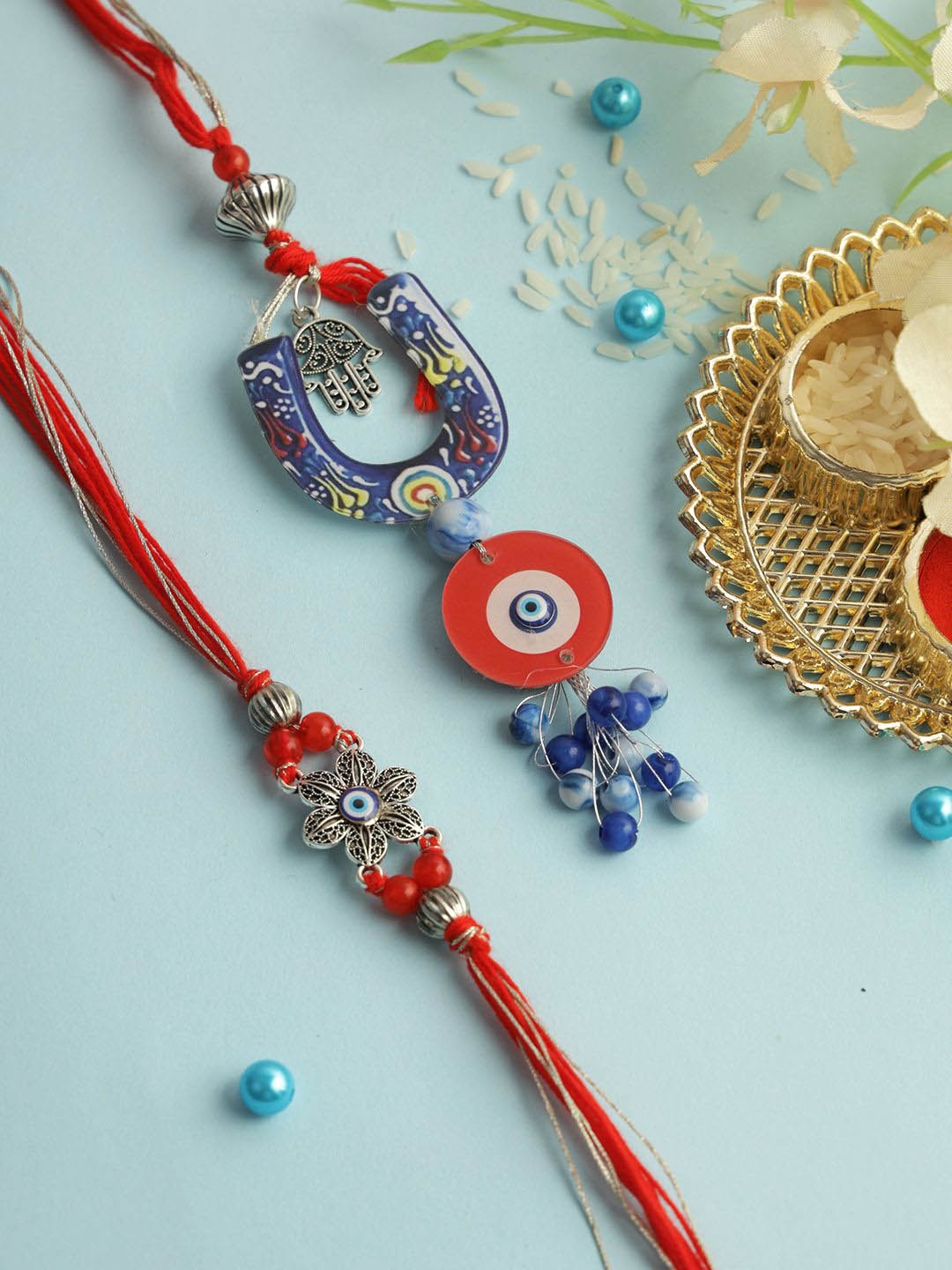 

Aapno Rajasthan Floral Evil Eye Bhaiya Bhabhi Rakhi with Roli Chawal & Greetings Card, Red