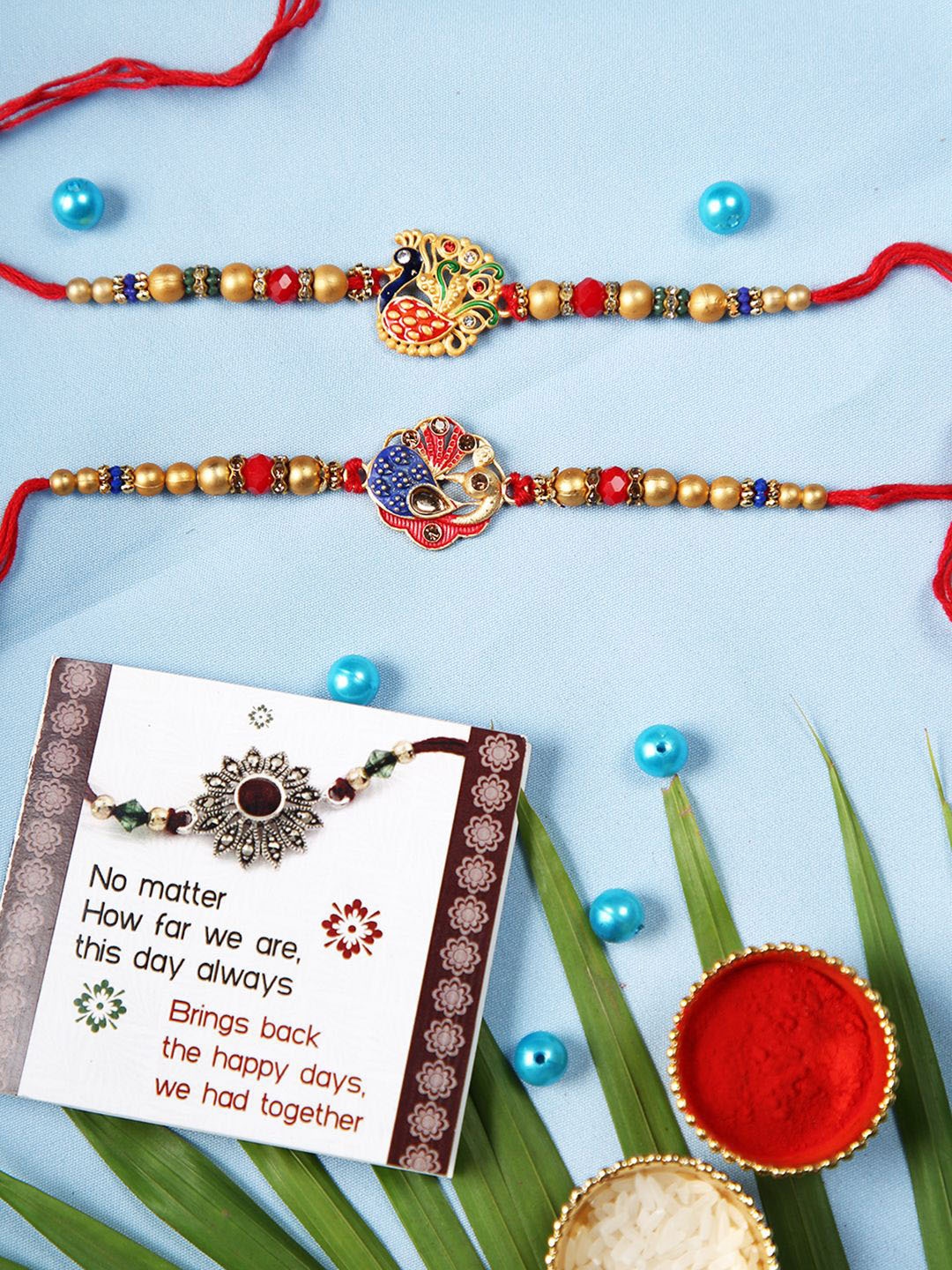 

TIED RIBBONS Set of 2 Designer Peacock Rakhis with Card & Roli Chawal, Red