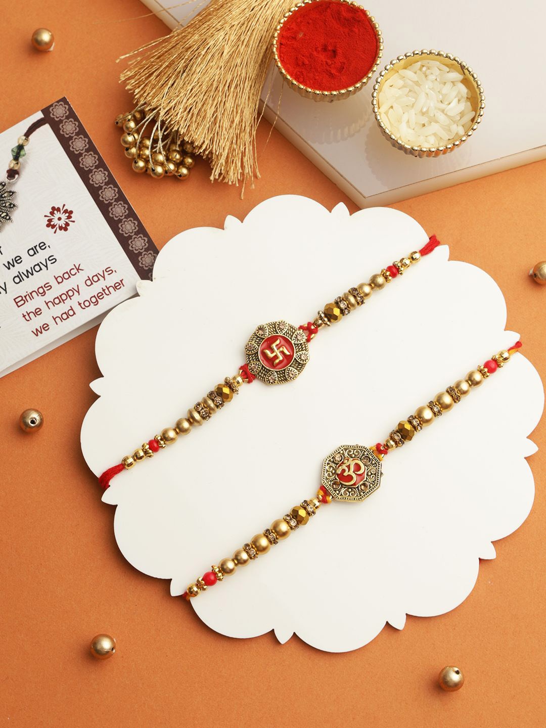 

TIED RIBBONS Set of 2 Pearl Om Rakhis with Card & Roli Chawal Combo, Gold