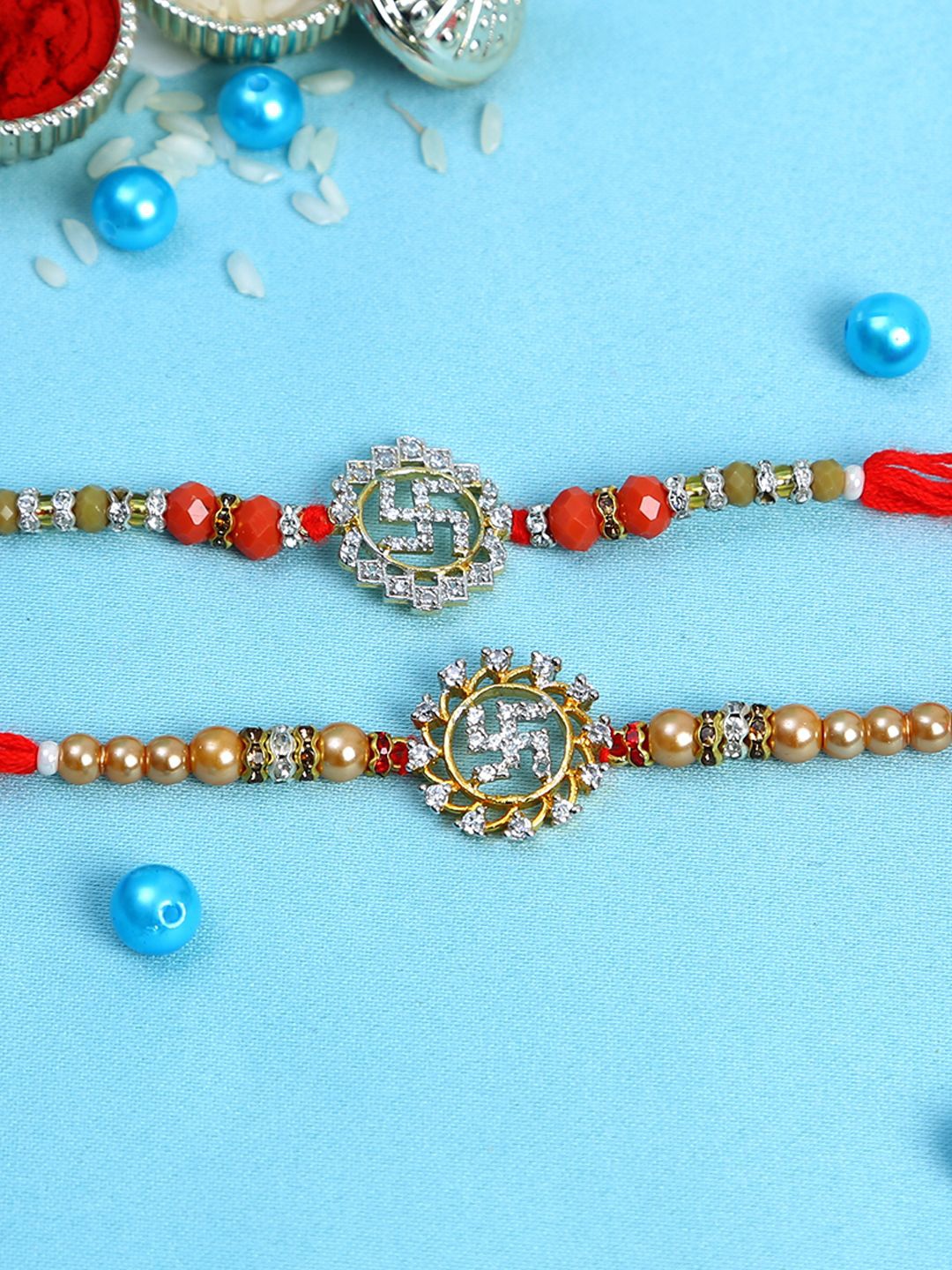 

Aapno Rajasthan Set Of 2 Swastika Stone Studded & Beaded Rakhi With Roli Chawal, Red