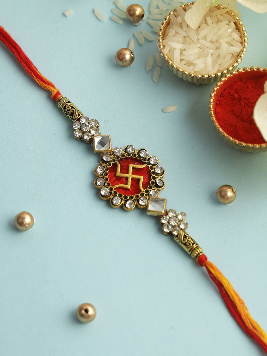 

Aapno Rajasthan Divine Swastik Gem Rakhi With Rholi Chawal & Greeting Card, Gold