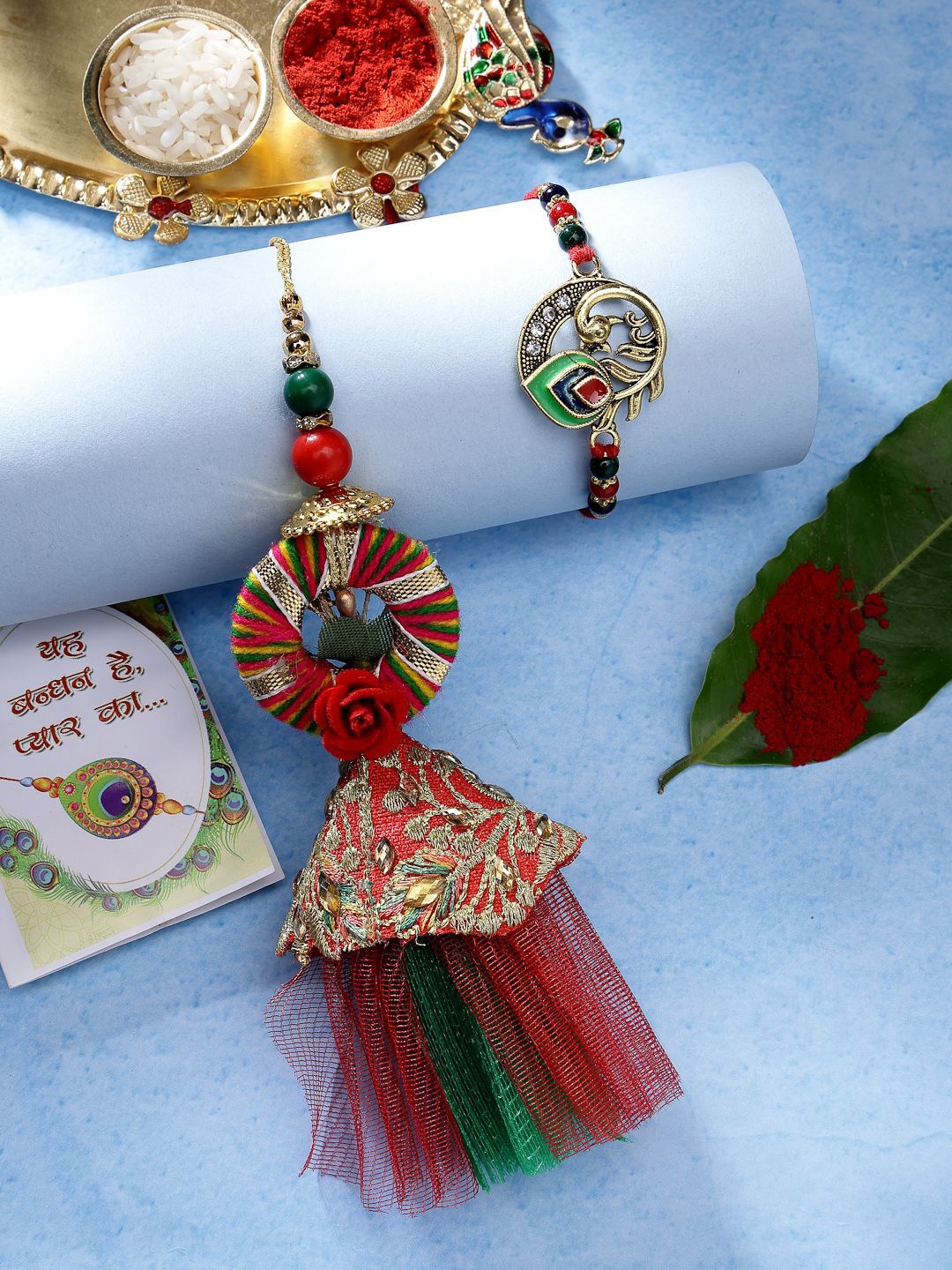 

NVR Set of 2 Peacock Design Rakhis With Chocolate & Greeting Card with Roli Chawal, Red